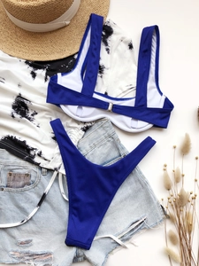 Flat lay of royal blue ribbed bikini set with back buckle and summer holiday accessories