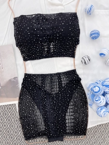 Vue détaillée du tissu en maille noire avec strass scintillants sur cet ensemble