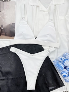 Close-up of white ribbed bikini featuring metal ring details and textured fabric