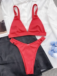 Detailed flat lay of red ribbed bikini set with adjustable straps and high cut bottom