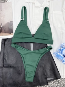 Detail view of dark green ribbed bikini set with metal rings on white shirt background