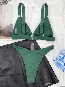 Detailed close-up of dark green ribbed bikini with metal buckle and adjustable straps