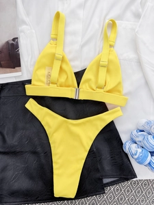 Detail of yellow ribbed bikini fabric and silver buckle on the two-piece swimsuit