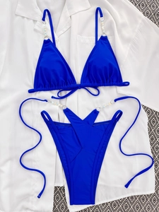 Detailed view of blue bikini with elegant faux pearls and metal ring connectors