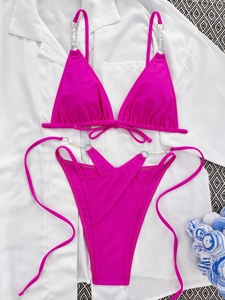 Close-up of hot pink bikini featuring elegant pearl beaded straps and metal ring details