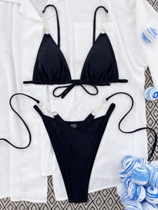 Two-piece black bikini with elegant pearl beads and crossover waist tie details