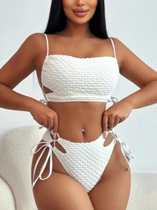 Detail des weißen Bikinis mit strukturierter Blasenoptik und seitlichen Kordelzügen