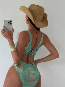 Detail of teal one-piece swimsuit with gold sparkles, open back and lace-up straps