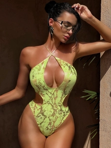 Close-up of metallic snake print texture and cutout details on neon green swimsuit