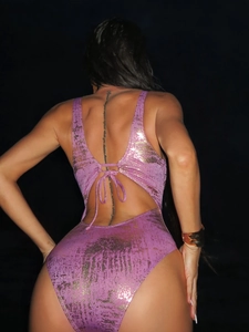 Detail of shimmering fuchsia metallic swimsuit with lace-up back and open back design