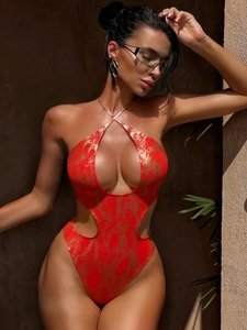 Close-up of red one-piece swimsuit with gold snake pattern and keyhole cutout design