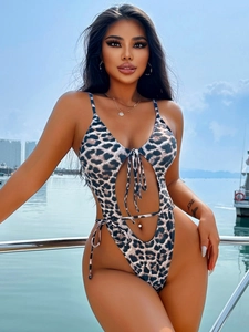 Sexy leopard print one-piece swimsuit with cutout design and tie front detail on a yacht