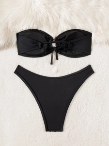 Detailed flat lay of black sequin bandeau bikini with center tie and gold ring detail