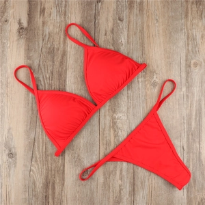 Detailed flat lay of a sexy red two-piece bikini set on a rustic wooden background