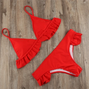 Detailed flat lay of red bikini set with ruffle trim on high-stretch fabric