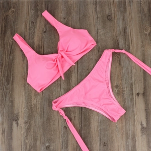 Close-up of bright pink two-piece bikini with wide straps and knotted detail