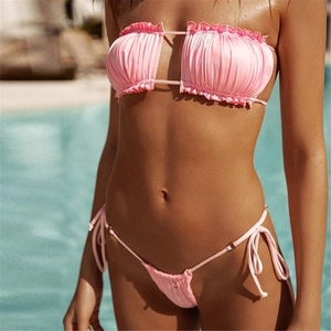 Detail of pink ruffled bikini top with hollow-out cut and side-tie swim bottoms