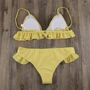 Detail of yellow bikini top featuring tiered ruffles and adjustable halter neck straps