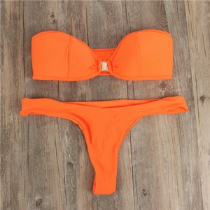 Detail of bright orange bikini set with a golden rectangular clasp on the bandeau top