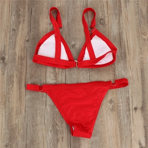 Flat lay of red two-piece bikini featuring silver metal rings and removable chest pads