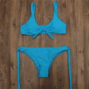 Flat lay of bright blue two-piece bikini featuring wide straps and adjustable front knot detail