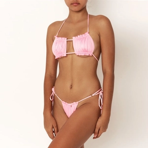 Detail of pink bikini set featuring halter neck ties and ruched fabric texture