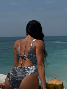 Detail of backless silver metallic one-piece swimsuit with lace-up ties and shimmer fabric