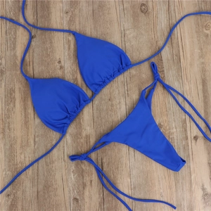 Flachbild eines dunkelblauen Schnürbikini-Sets mit Bindedetails auf Holzgrund