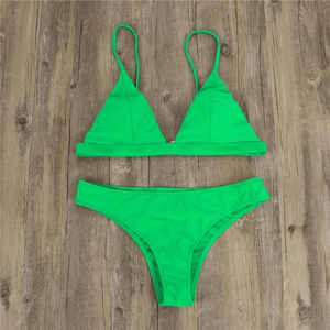 Close-up of neon green bikini set featuring triangle cups on a wooden background