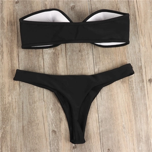 Detailed flat lay of black bandeau bikini top with inner lining and matching thong bottoms