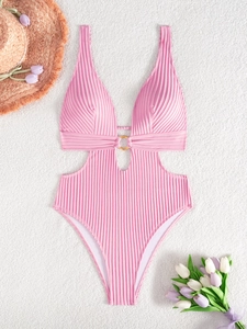 Pink ribbed one-piece swimsuit with cutout waist and gold ring detail on plush background