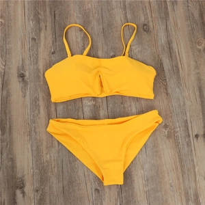 Flat lay of yellow two-piece bikini featuring bandeau top with ruching and matching bottoms