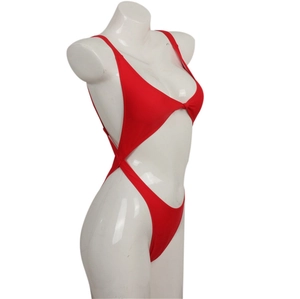 Detail of red one-piece swimsuit with waist cut-outs and knot decoration on white mannequin