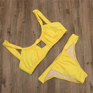 Detailed view of neon yellow bikini with ruched fabric and hollow cut-out design