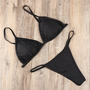 Flat lay of a black two-piece string bikini with gathered triangle cups and thong bottom