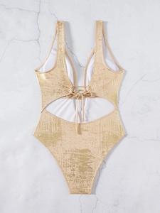 Detail of gold metallic swimsuit fabric with deep V-neck, ring hardware, and cutout design