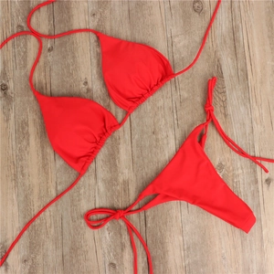 Detaillierte Flachbildaufnahme eines hellroten Bikini-Sets auf hellem Holzhintergrund