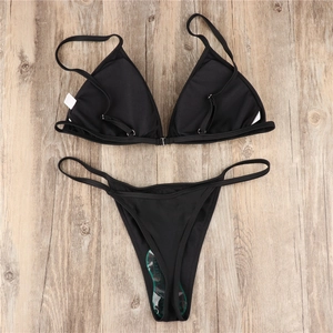 Black triangle bikini set featuring thin straps and thong bottom on wooden background