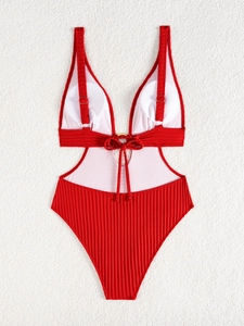 Close-up of red ribbed monokini swimsuit featuring deep V-neck and golden metal ring detail