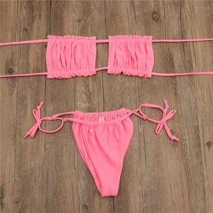 Flat lay of rose pink two-piece bikini with ruched bandeau top and side tie bottoms
