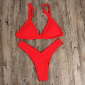 Flat lay of a red two-piece bikini set with triangle top and high-cut V-shaped bottoms