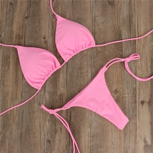 Flach liegender pinker Bikini mit strukturierter Optik auf Holzgrund