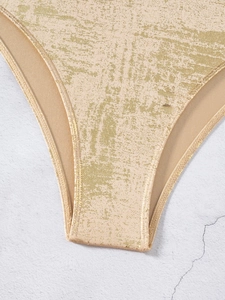 Detailed close-up of metallic shimmering fabric and stitching on a deep V-neck swimsuit