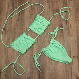 Flat lay of mint green bikini top featuring ruffled double-layered texture and drawstring