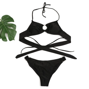 Detailed flat lay of black bikini with metal ring accents and long cross straps