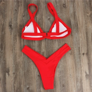 Detailed flat lay of vibrant red two-piece bikini set with high waist bottom on wood
