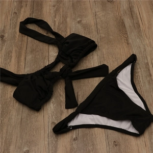 Detail view of black two-piece bikini featuring pleated texture and center bow tie detail