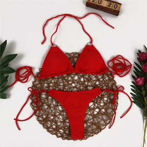 Detailed top view of red bikini set with metallic ring accents on a straw mat