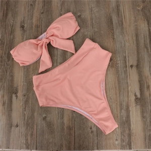 Bikini côtelé rose avec nœud décoratif et culotte taille haute sur fond bois