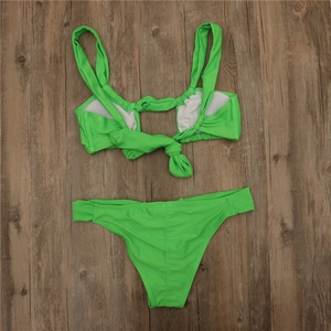 Detailed flat lay of fluorescent green bikini set with wide straps and knotted back detail